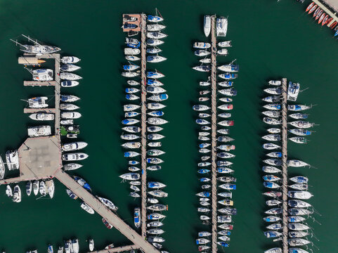 Boats and small sailing Yachts docked in a beautiful marina, Top down view