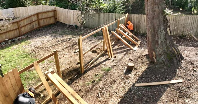 Aerial View of Fence Being Built By Two Workers in a Suburban Backyard