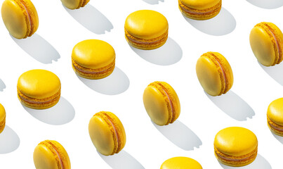 Lemon yellow macarons pattern on white background isolated with hard shadows