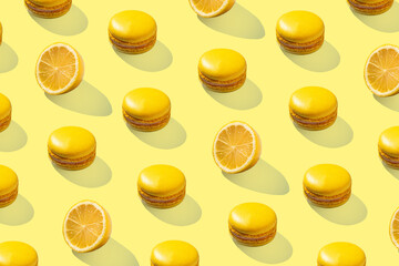 Yellow macarons with lemon pattern on yellow background isolated with hard shadows