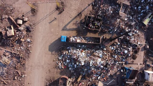Crane sorting through scrap metal at scrapyard