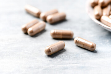 Guarana capsules. Bright wooden background. Close up. Copy space.	