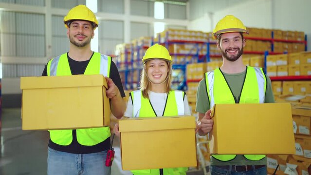 Success partnership man and woman wear uniform shirt carry cardboard box smiling looking at camera at warehouse together. Shipping concept.