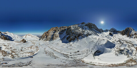 A huge frozen glacier in the mountains and a lot of tourists. 360 panorama. Walking in the snow, taking pictures with ice. Top view from a drone. Ice resembles marble. Dark light gray tones.