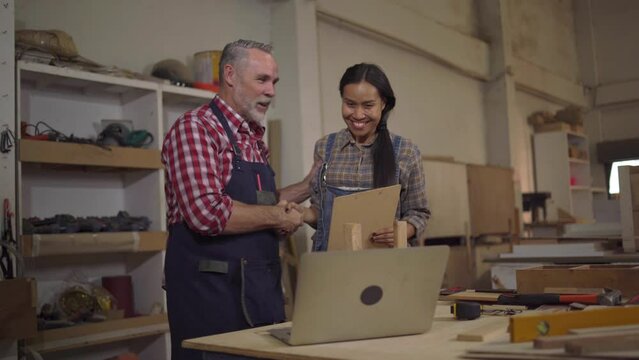 4K Carpenter couples are talking to customers online or over the phone. They're presenting about woodworking and delighted after closing the big lot sale at Wood Factory in wood craftsmanship concept.