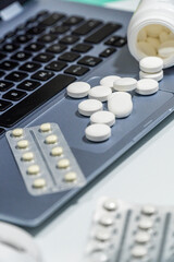 Pills and anxiolytics on the office desk, next to a laptop
