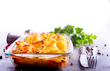 Savory food: baked cauliflower with cheese, eggs and cream close-up in a baking dish on a table.