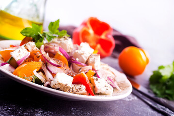Greek salad of fresh cucumber, tomato, sweet pepper, lettuce, red onion, feta cheese and olives with olive oil. Healthy food, top view