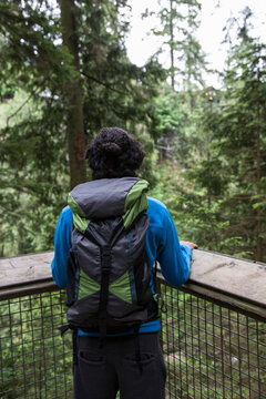Hiker with backpack looking at view in forest