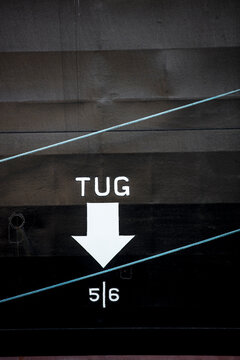 Close-up of tug text with arrow symbol on boat