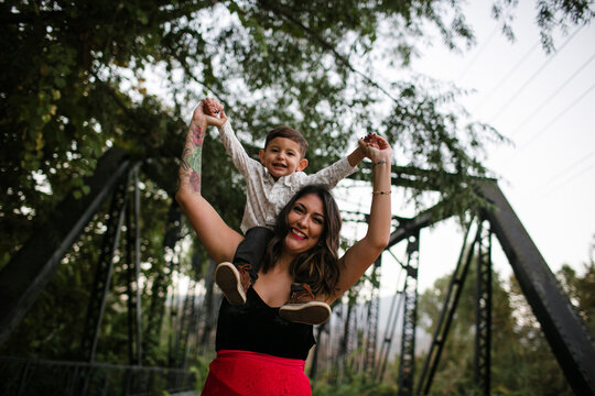 Portrait of happy mother and son on bridge
