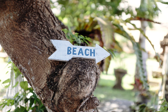 Close-up of beach text on wooden arrow