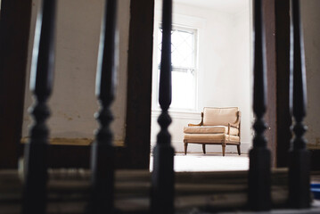 Chair in domestic room seen through metallic railing