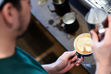 High angle view of barista making frothy drink at coffee shop