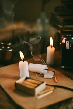 High angle view of burning candles with matchbox and envelop on table