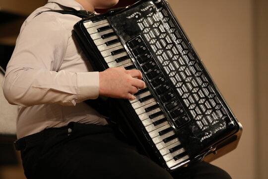 A person playing the accordion hand on the keys