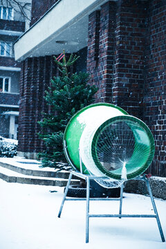 Equipment and Christmas Tree by building during snowfall