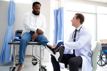 Obraz premium Male doctor treating foot injury patient.