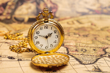 Ancient gold pocket watch on vintage marine map.
