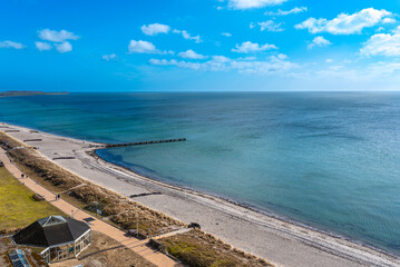 Obraz premium White sandy beach at the coastline of the Baltic Sea on the island of Fehmarn in the north of Germany. The south beach is situated in the tourist resort of Burgtiefe