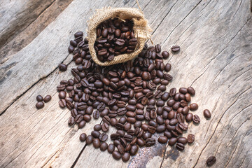 black drip coffee in ceramic cup on old wood table with coffee bean. Barista serve cup of hot black coffee on old wooden table cafe shop in garden with coffee bean.