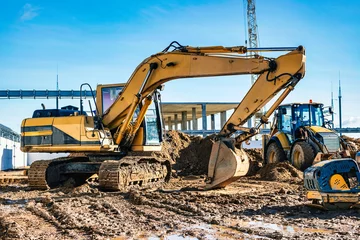 Fotobehang Yellow crawler excavator at the construction site. Earthworks at a construction site. Modern earthmoving equipment. © Anoo