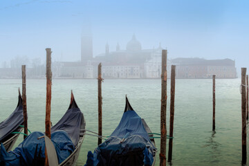 Venezia. Gondole al palo in laguna con foschia verso l'isola con basilica di San Giorgio Maggiore