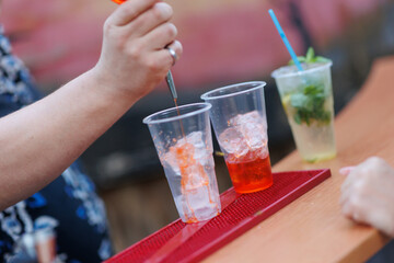 A professional bartender makes cocktails at the bar. Blurred Mojito cocktail in the background.