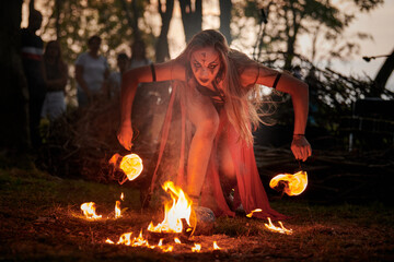 Girl fire dancing performance at outdoor art festival, smooth movements of female fire show artist...