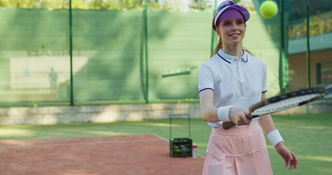caucasian happy red-haired female tennis player holding racket and bouncing ball. professional tennis training, sport and competition concept. ball is falling, girl is sad, angry unhappy slow motion