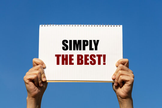 Simply the best text on notebook paper held by 2 hands with isolated blue sky background. This message can be used as business concept about making thing simple is the best