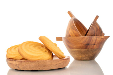 Several sweet cookies on a wooden plate with wooden cups, macro, isolated on white background.