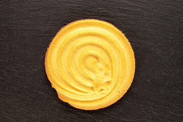 One sweet cookie on slate stone, macro, top view.