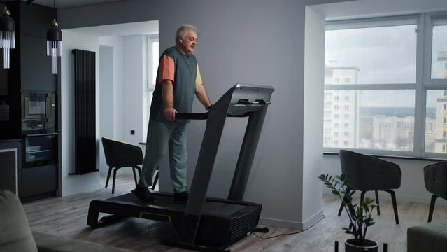Senior Man Walking On Treadmill At Home, Training Cardiovascular And Respiratory Systems