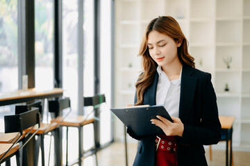 Confident business expert attractive smiling young woman holding digital tablet  on desk in creative office.