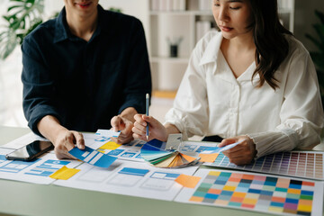 Fototapeta premium UX developer and ui designer brainstorming about mobile app interface wireframe design with customer breif and color code at office..
