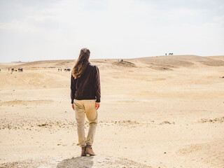 Stylish woman and the sights of the Wadi Rum desert in Jordan. Clear, sunny day. Vacation and travel concept