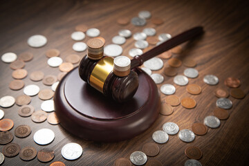 Stack of coins with judge gavel.