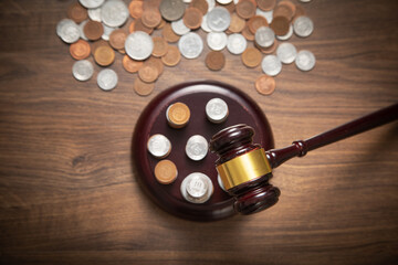 Stack of coins with judge gavel.