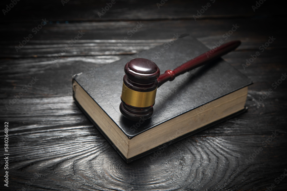 Wall mural judge gavel and book on the black table.