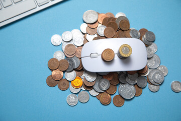 Computer mouse and coins on the blue background.