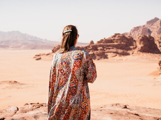 Stylish woman and the sights of the Wadi Rum desert in Jordan. Clear, sunny day. Vacation and...