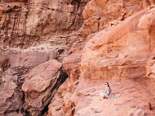 Stylish woman and the sights of the Wadi Rum desert in Jordan. Clear, sunny day. Vacation and travel concept