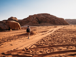 Stylish man and the sights of the Wadi Rum desert in Jordan. Clear, sunny day. Vacation and travel concept