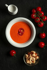 tomato cream soup in white bowl on black desk