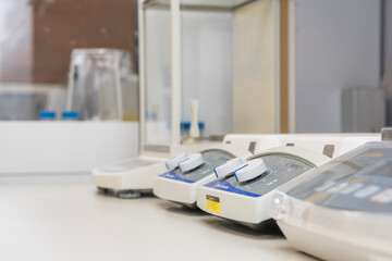 Side view of stirring plates and an analytical balance in a laboratory.