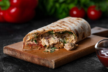 Shawarma sandwich fresh roll of, Grilled Meat and salad with white sauce on black background.