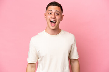 Young Brazilian man isolated on pink background with surprise facial expression