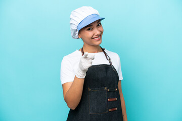 Fishwife Argentinian woman isolated on blue background pointing front with happy expression