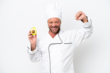 Chef man holding an avocado isolated on white background doing strong gesture